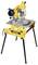 A yellow and black table circular saw mounted on a stand, with a silver, rotating saw blade, suitable for woodworking.