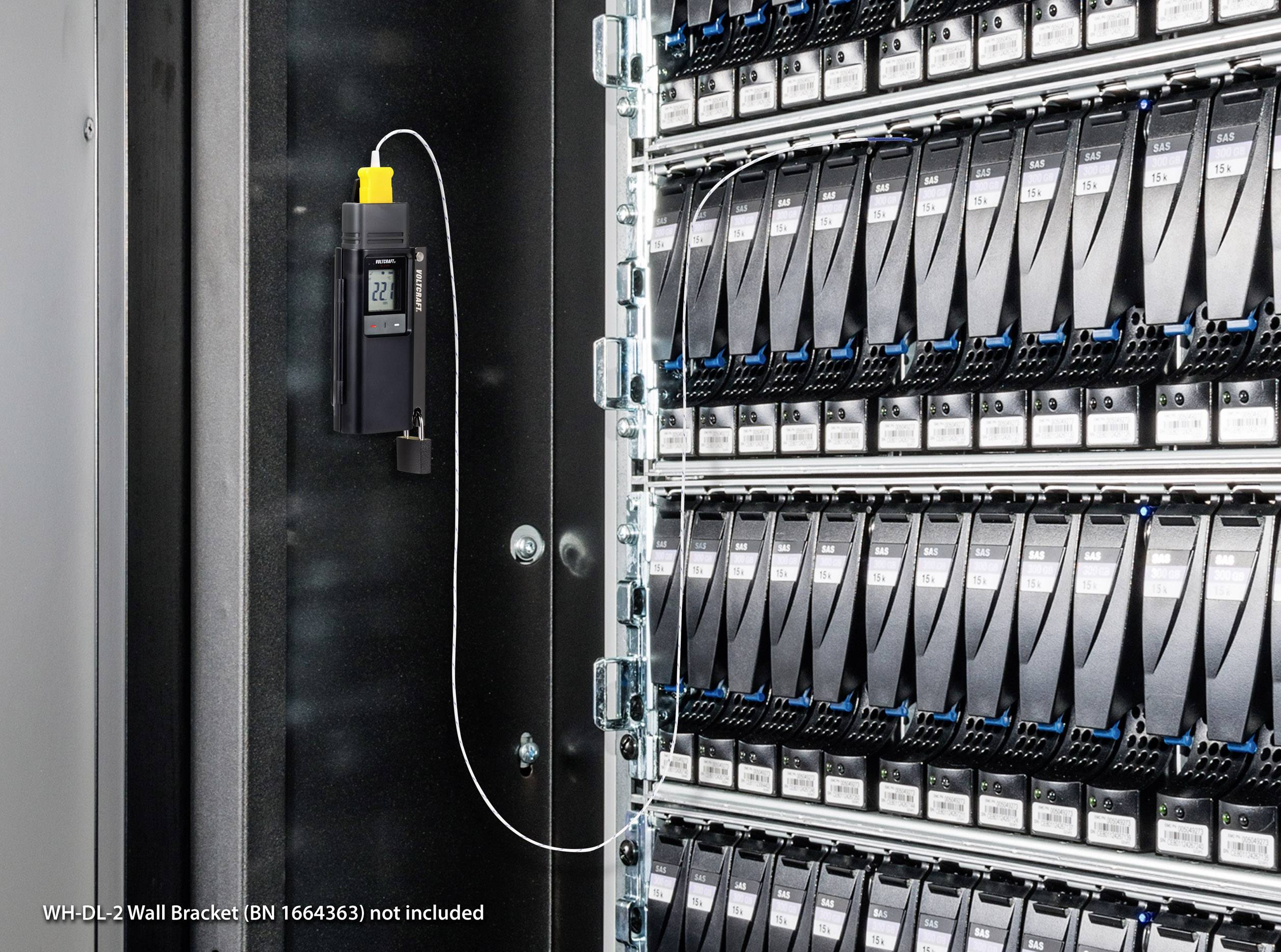 A data logger is installed in a server room, secured to a cabinet with numerous storage modules.