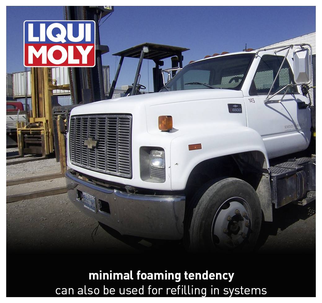 A white lorry on an industrial site. The image advertises a Liqui Moly product with the characteristic of 'minimal foam formation'.