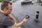A man is using a thermal imaging camera to measure the temperature on a flat roof. The camera displays different colour ranges.
