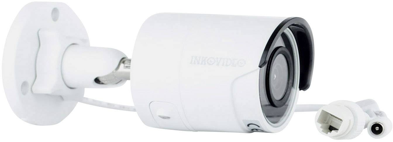 Security camera mounted on a wall bracket, with cable connection. It is white and compact, suitable for indoor and outdoor use.
