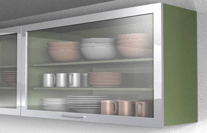 A kitchen wall cupboard with a glass door displays stacked plates, cups, and bowls on three shelves.