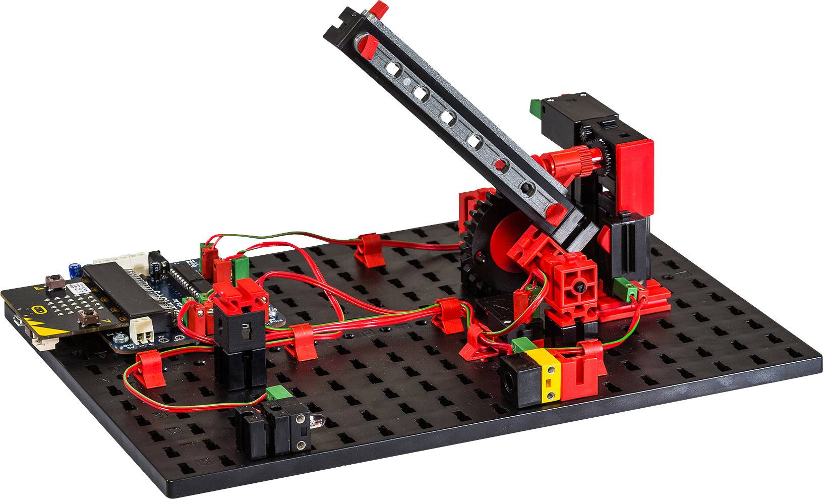 A robot construction kit with red and black components on a base plate. Cables connect modules for power supply.