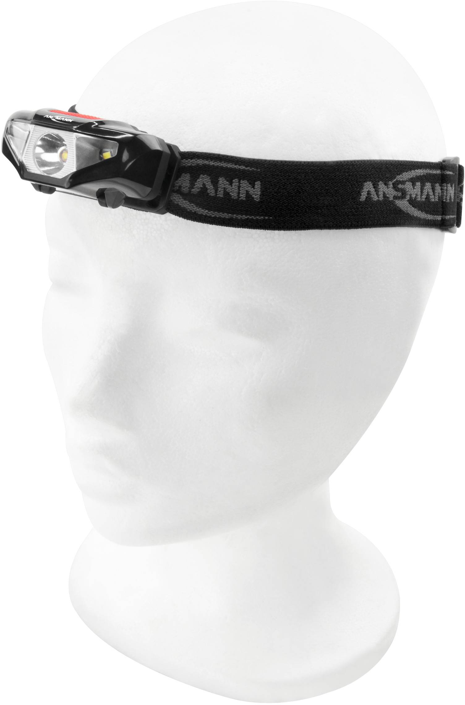 A black head torch with an elastic band on a white head model.