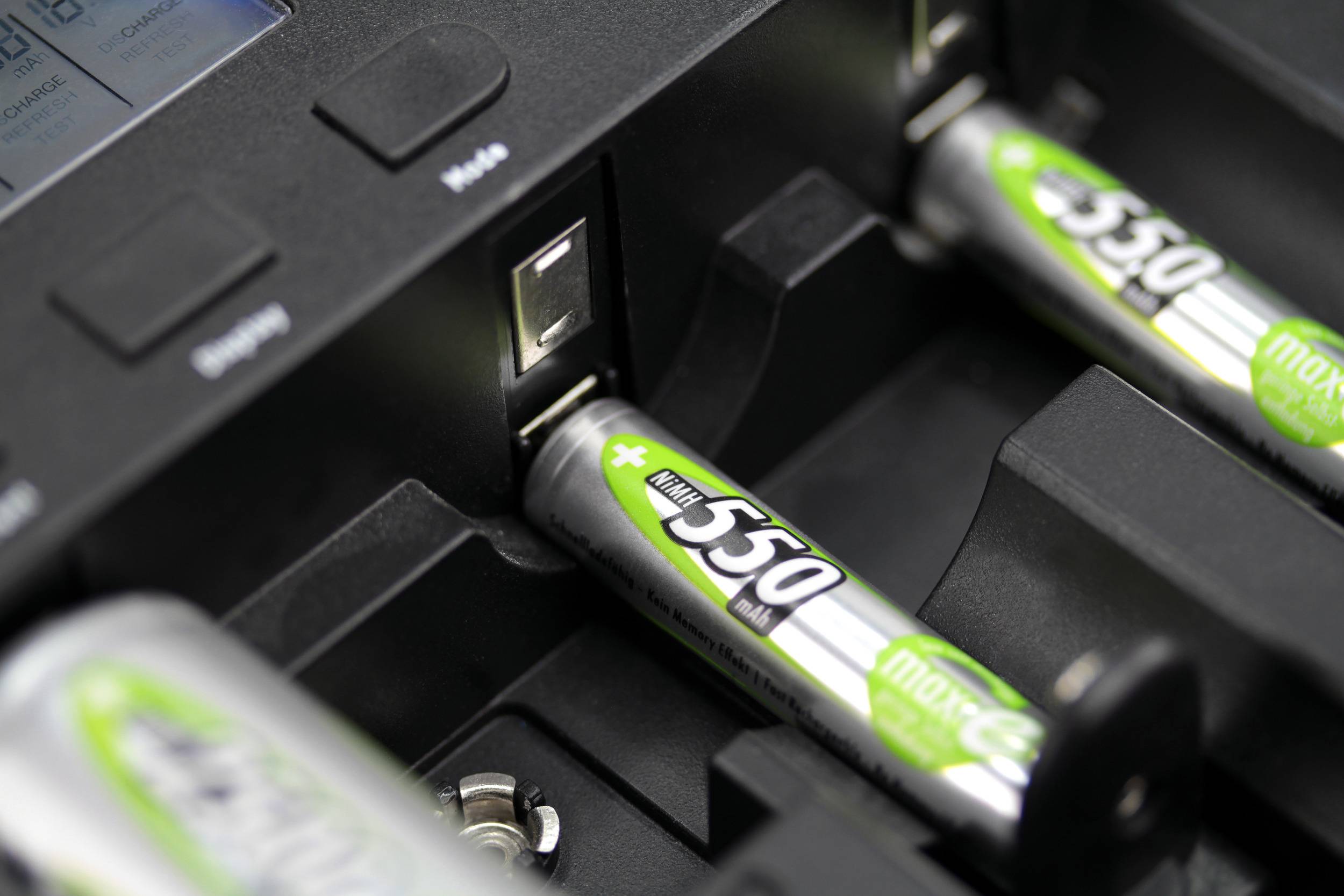 Battery charger with batteries inserted. An LED indicator shows the charging status. Batteries are marked '550 mAh'.