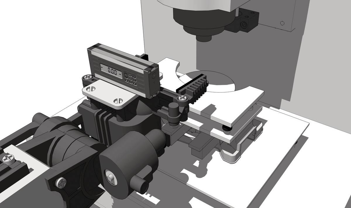 A microscope with a digital measuring device shows an object on a table. A precision instrument for accurate analysis.