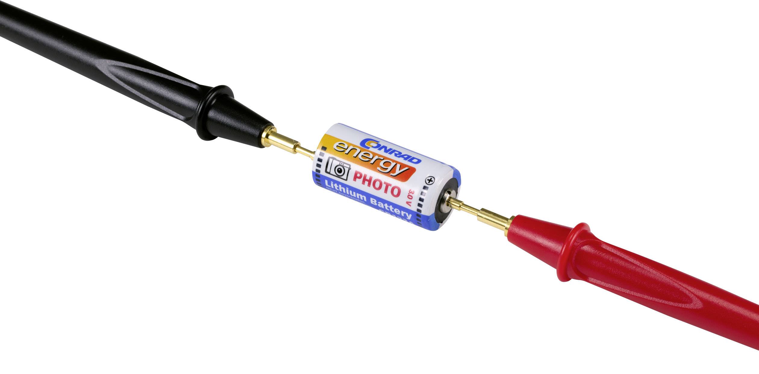 A lithium battery with a yellow and blue label is being held by two measuring leads, one red and one black.