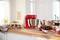 A red stand mixer on a kitchen counter next to a plate of brownies and a glass of dessert. Blurred kitchen in the background.