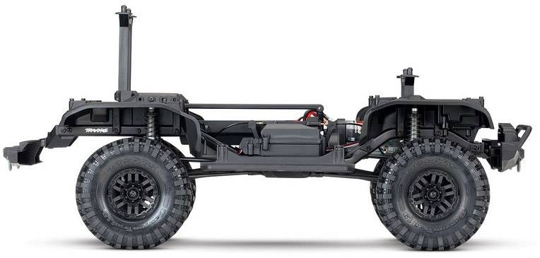 The image shows the chassis of an RC off-road vehicle without bodywork. Large tyres, suspension, and drivetrain are visible.