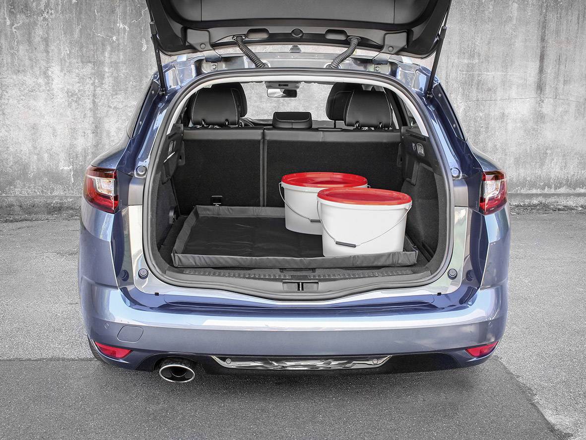 A blue estate car with its boot open reveals two white buckets with red lids in the boot space. The car is parked on tarmac in front of a concrete wall.