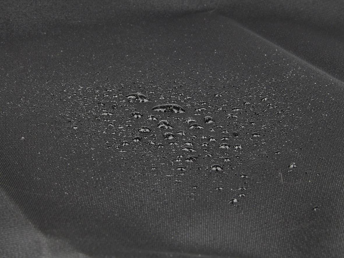 Water droplets on black, water-repellent fabric demonstrate its resistant nature.