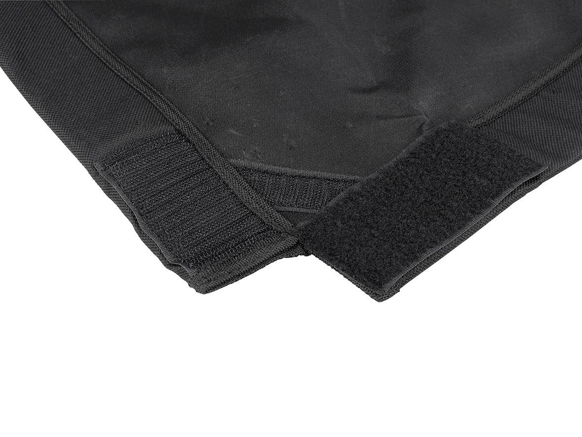 Black fabric with a hook and loop fastener in close-up, showing a method of attaching or adjusting clothing or accessories.