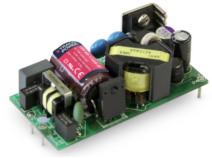 An electrical circuit board with multiple components such as capacitors and transformers, mounted on a green circuit board.