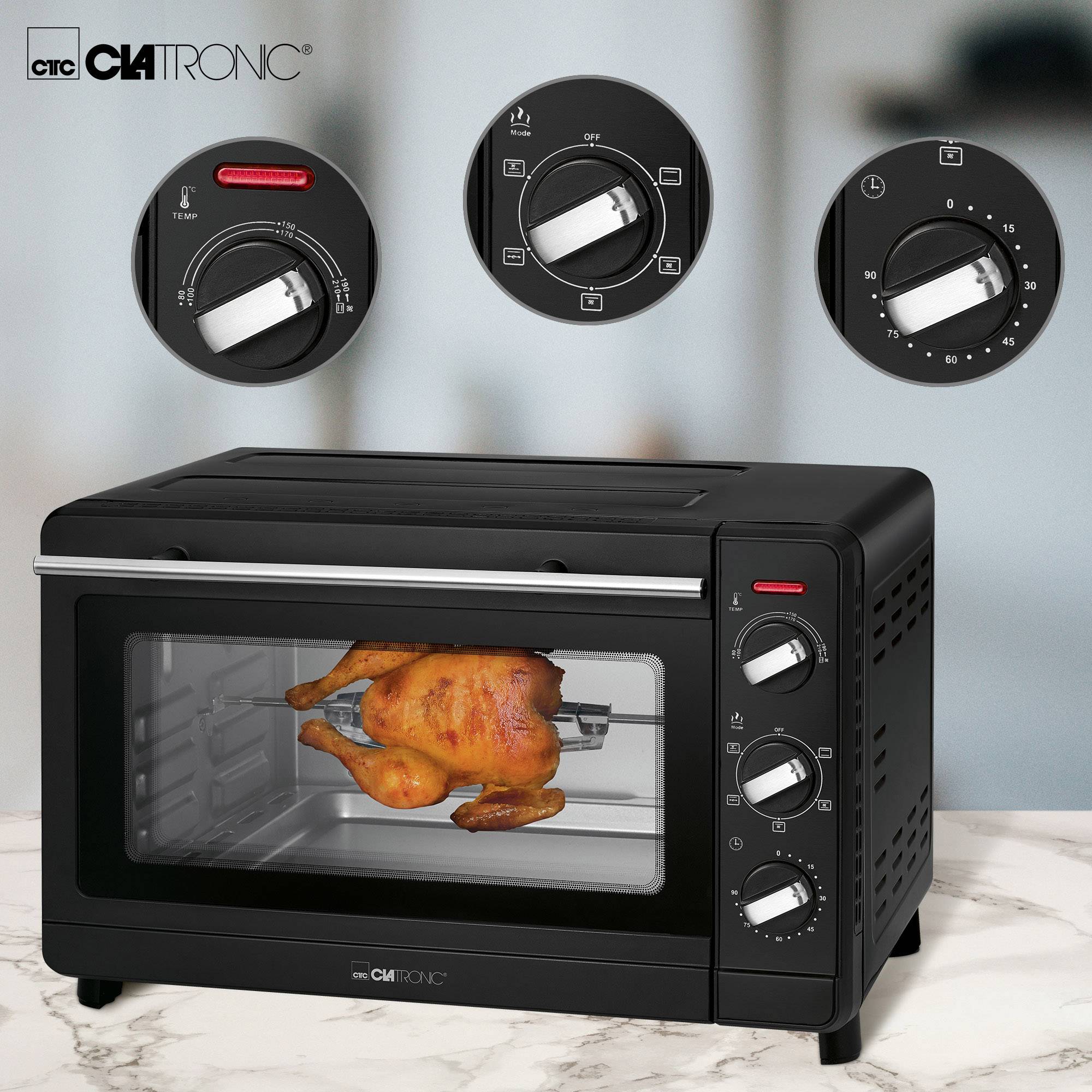 Black oven with a rotating chicken inside. Three rotary knobs on top showing temperature settings and functions.
