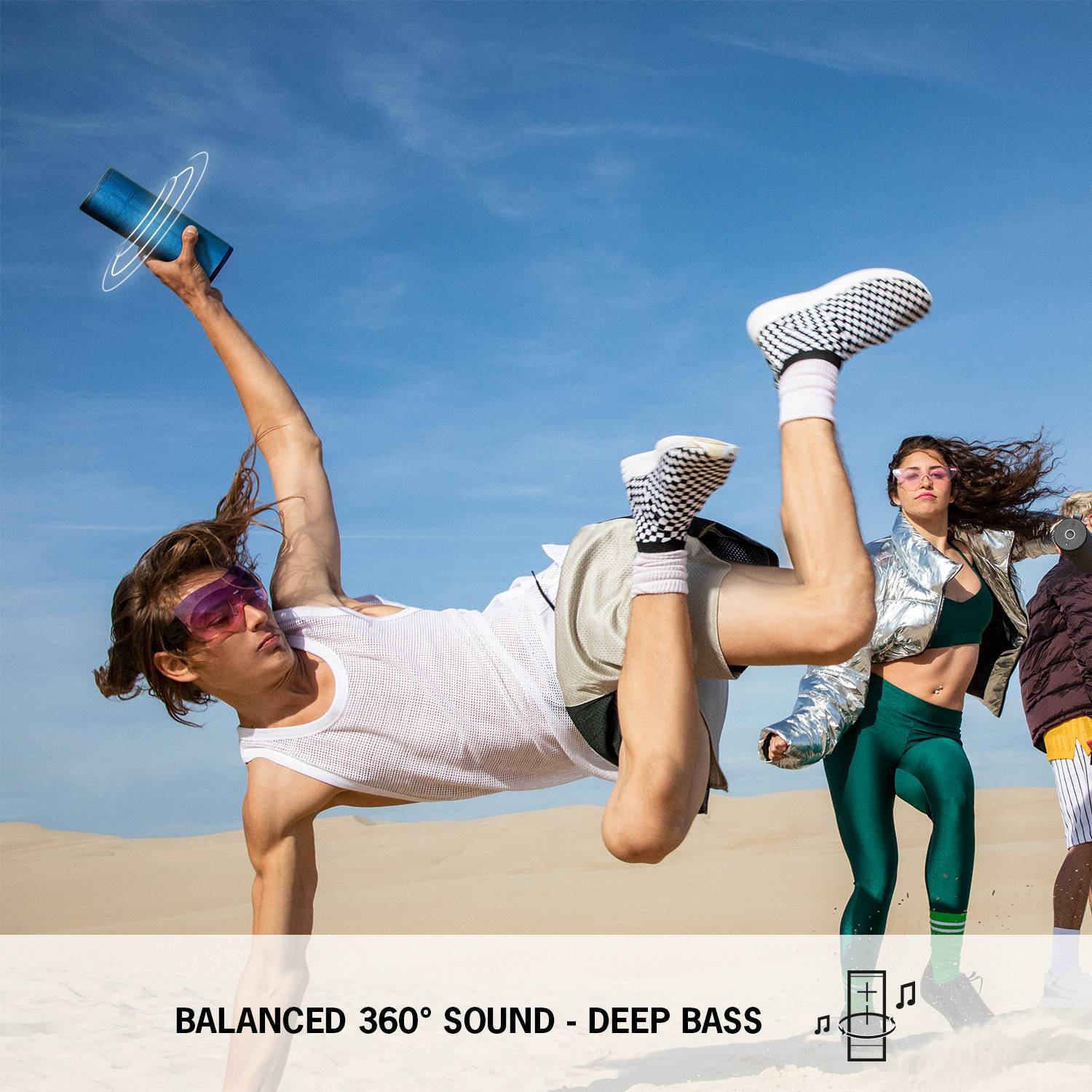 Young people dance energetically on the beach in light clothing. Below it says: 'Balanced 360° sound with deep bass'.<br><br>Note: This translation is already in British English, so no significant changes were needed.