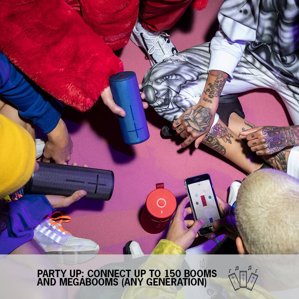 People are sitting in a circle holding portable speakers. One person is using a smartphone. Text: 'Party Up: Connect 150 Booms and Megabooms'.