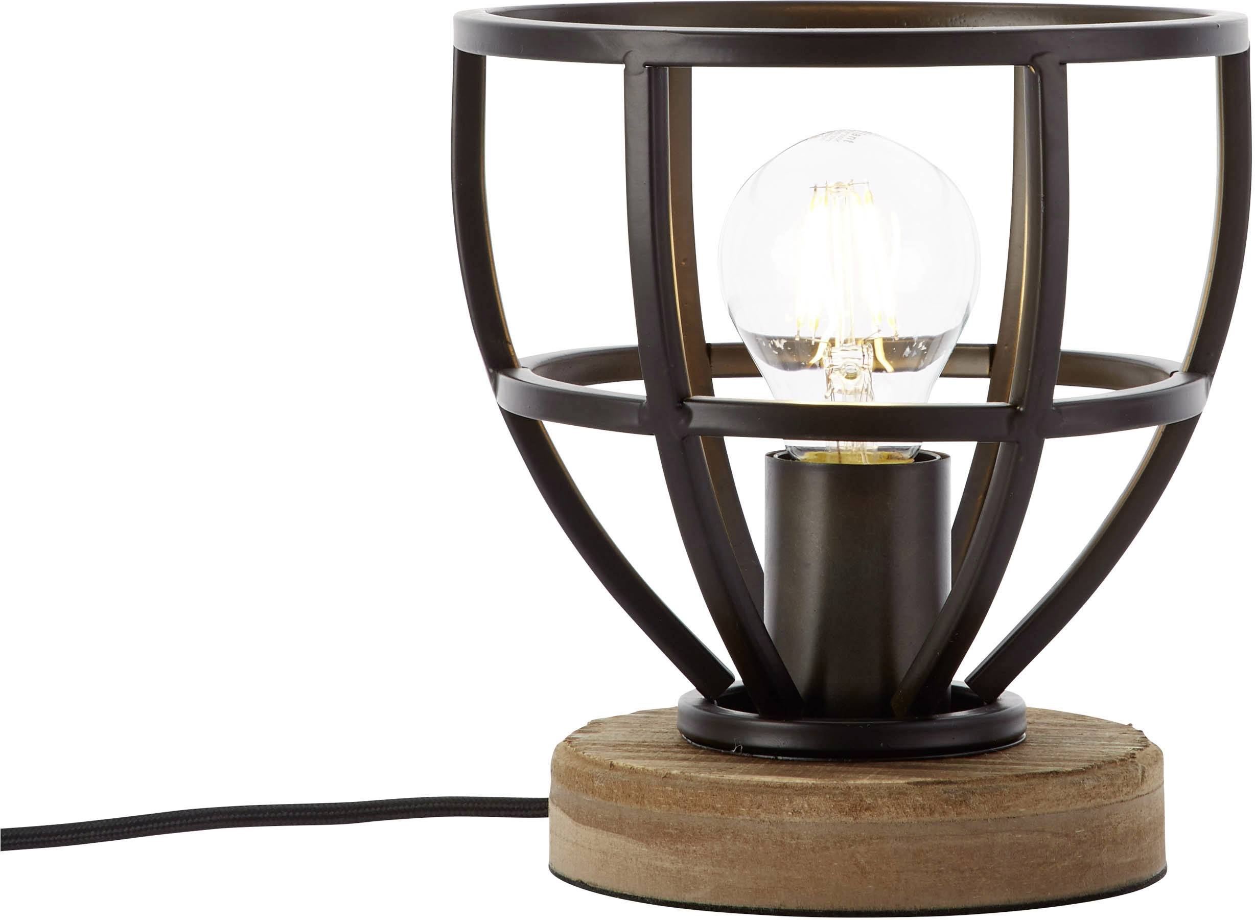 Desk lamp with a metal cage design on a wooden base, switched on; warm glow of the light bulb visible.
