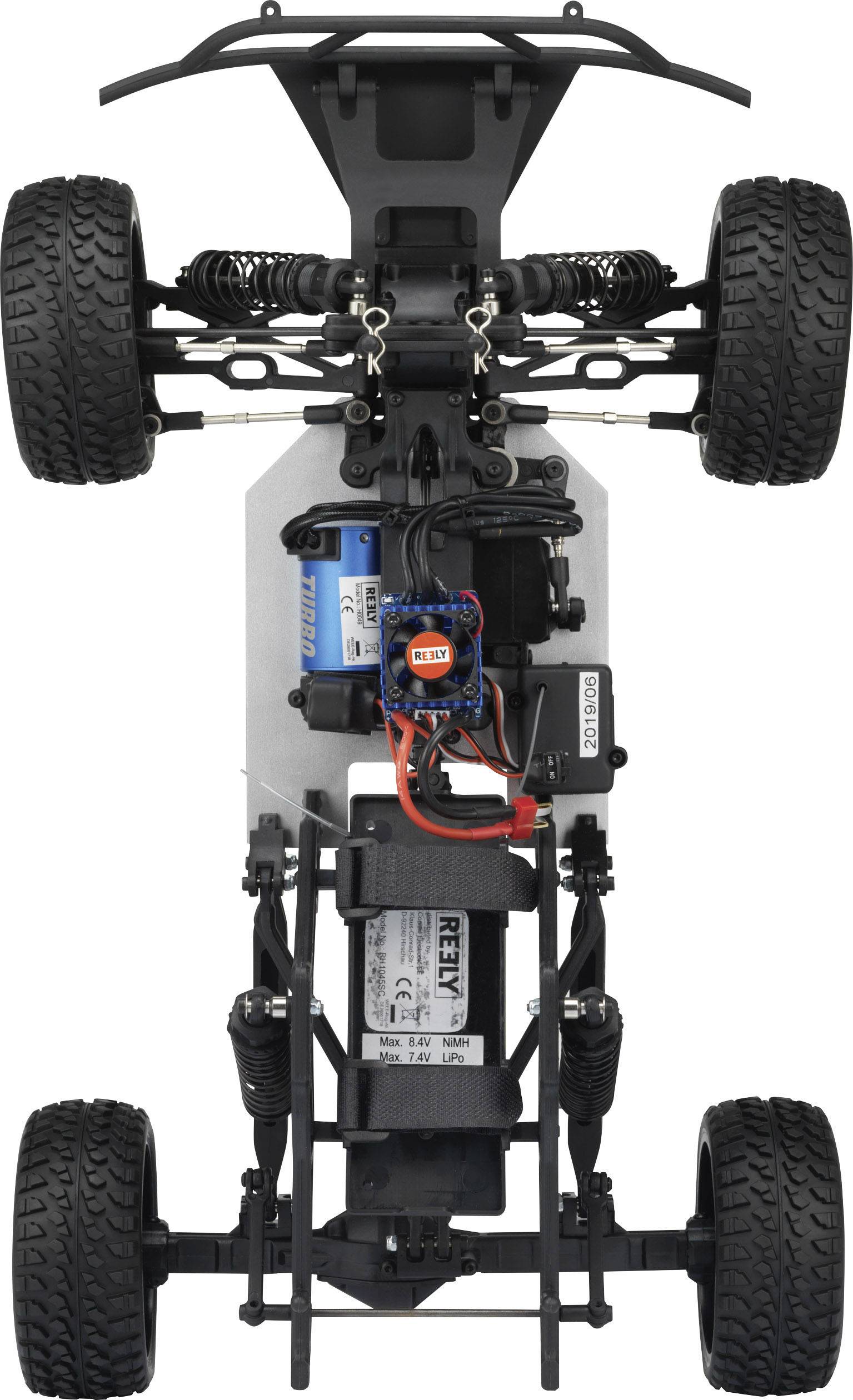 The image shows the chassis of a remote-controlled car from underneath, with visible wheels, suspension, and electronic components.