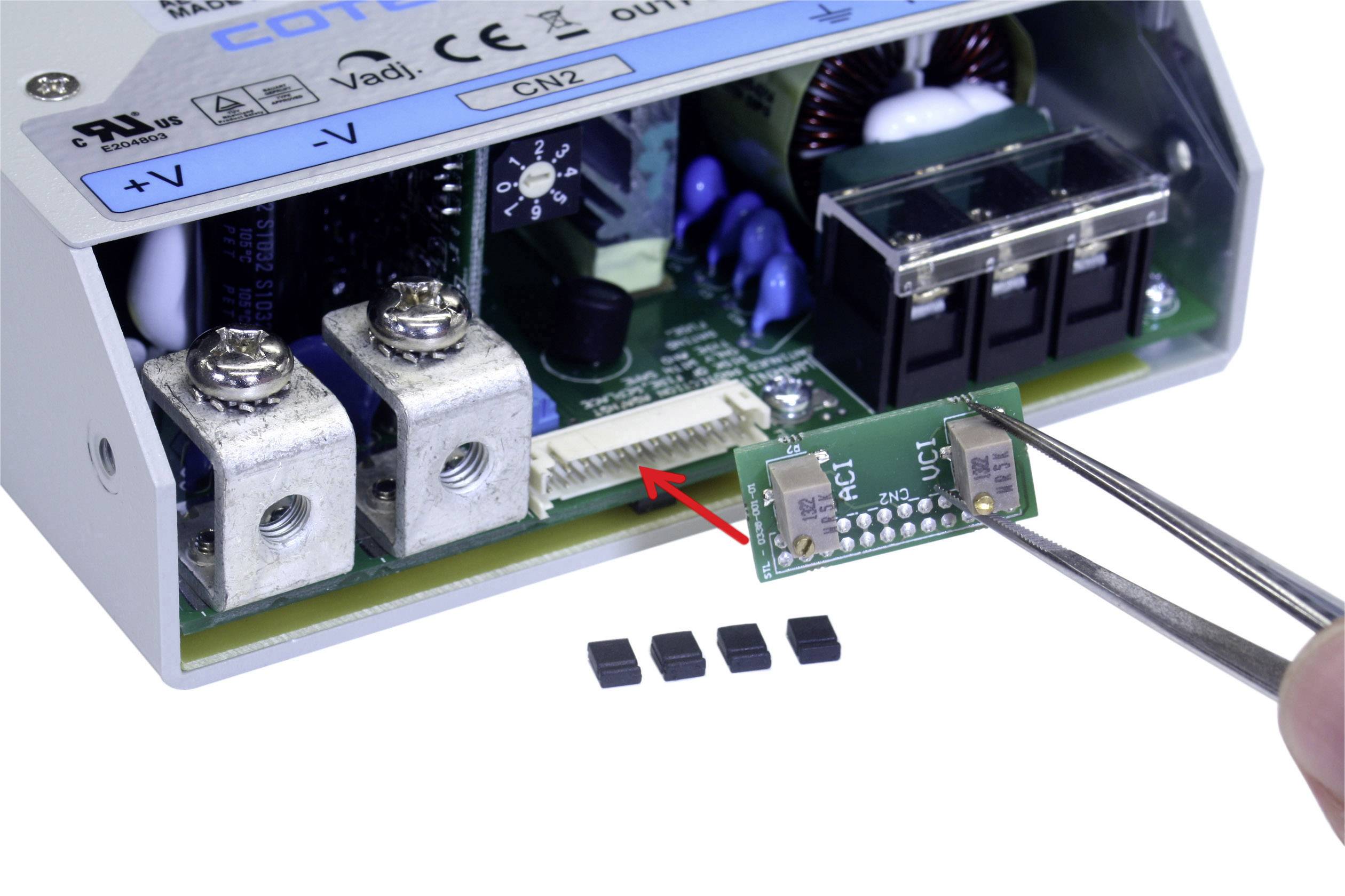 An electronic component is being inserted with tweezers into a connection of an open circuit in the device.