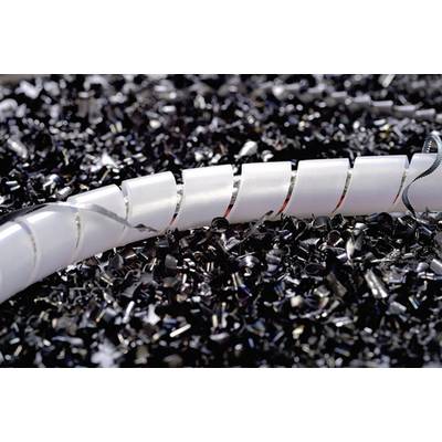 A white plastic tube lies on a pile of black plastic shavings. The focus is on the texture and contrasts of the materials.