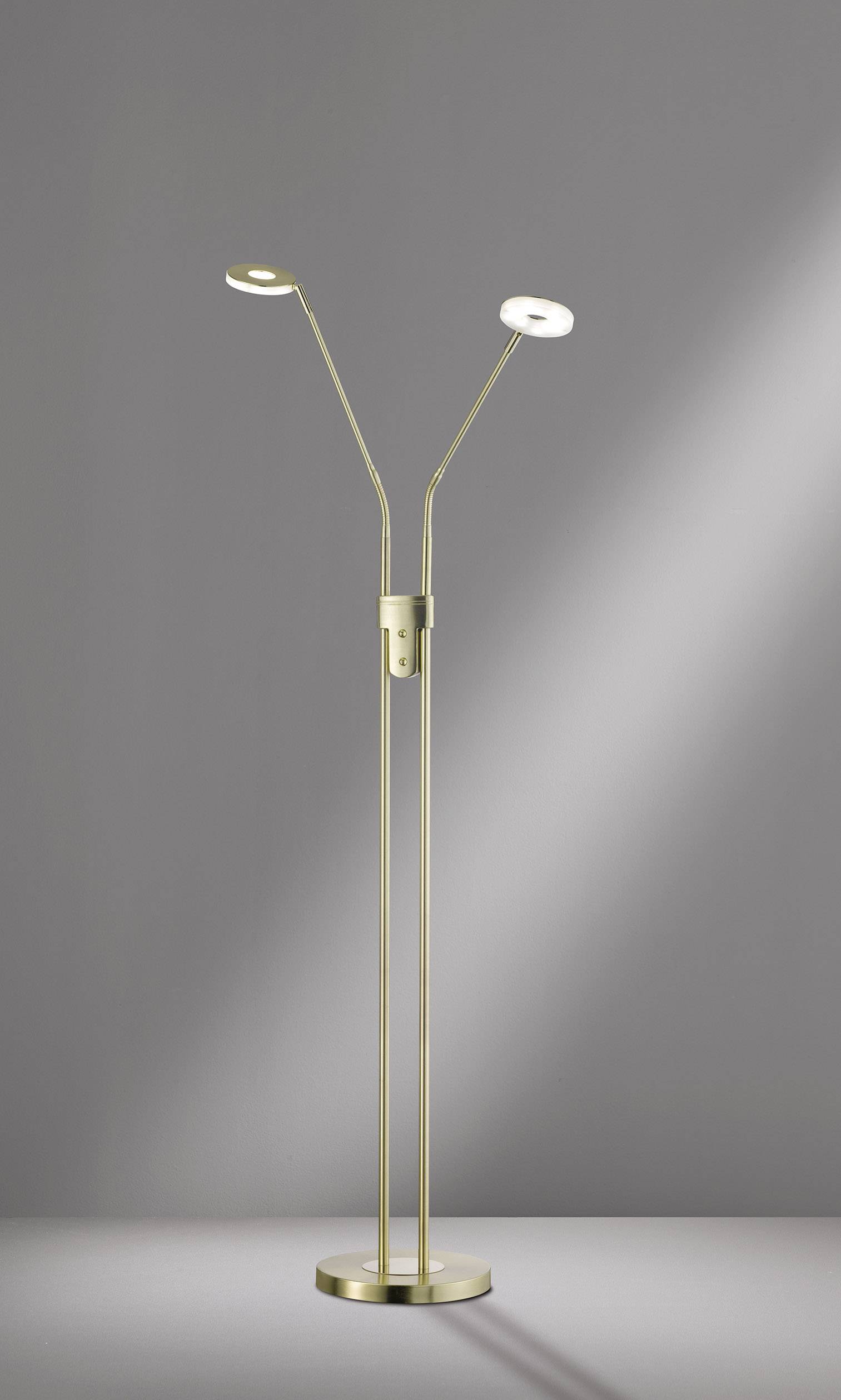 Floor lamp with two adjustable, round lampshades. Sleek, modern design in gold-coloured metal, standing on a round base.
