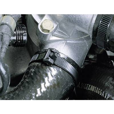 A black cable tie secures a black rubber hose to a silver metal valve in an engine bay.