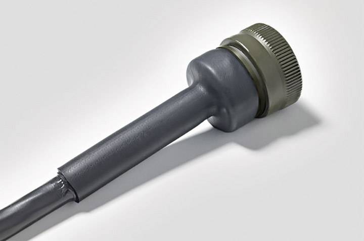 A grey electrical plug with a metal thread is lying on a light surface.