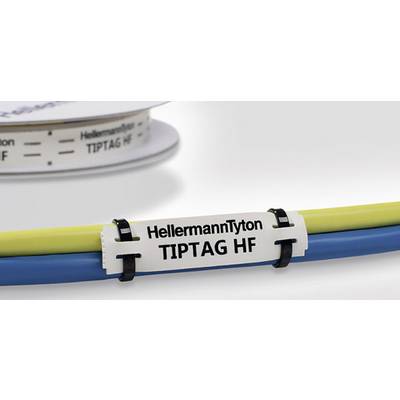 A white cable label with the inscription 'HellermannTyton TIPTAG HF' is attached to yellow and blue cables. A spool is visible in the background.