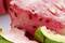 Ants are crawling on a juicy piece of red watermelon with a green rind.
