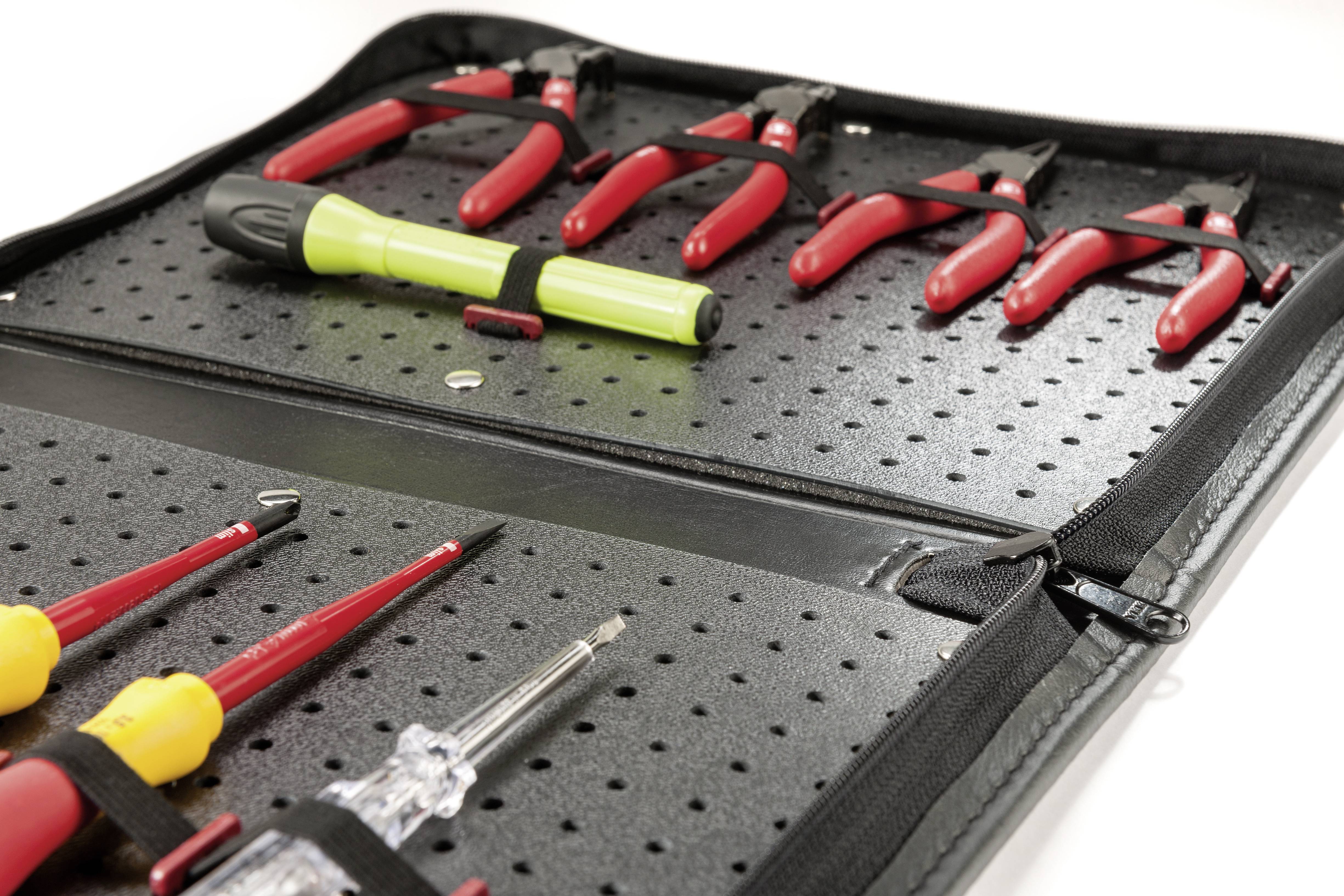 An open tool bag displays a range of screwdrivers and pliers. A green screwdriver lies next to red pliers.