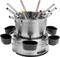 A silver fondue pot with several long forks, each with a coloured dot on top. The pot is situated on a heated stand.