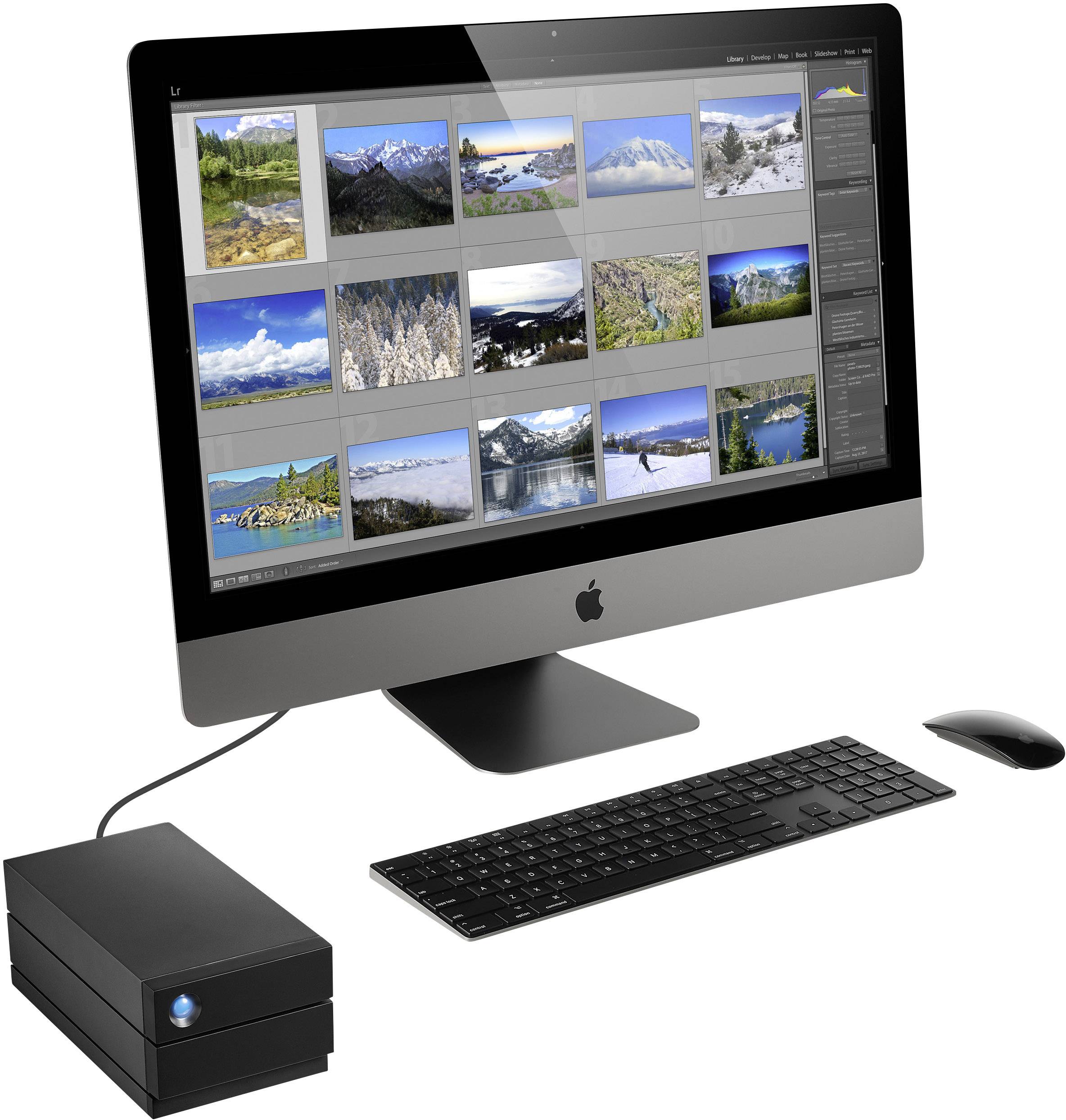 A computer with a large screen displays image editing software with multiple landscape photographs. An external hard drive is connected.