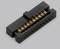 Black electrical connector with multiple golden contacts, on a grey background.