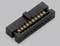 A black electrical connector on a grey background, with visible golden contacts.