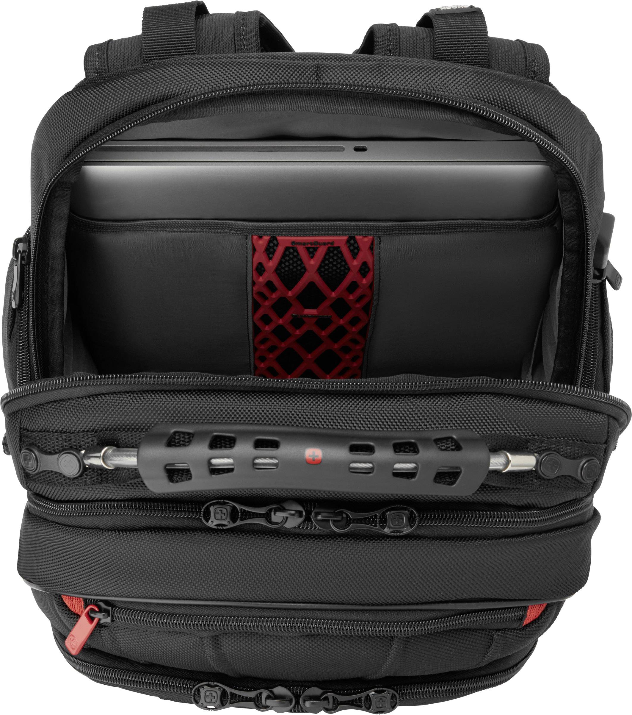 A black rucksack with three compartments, one showing a laptop and a red mesh pattern. Zips are visible.