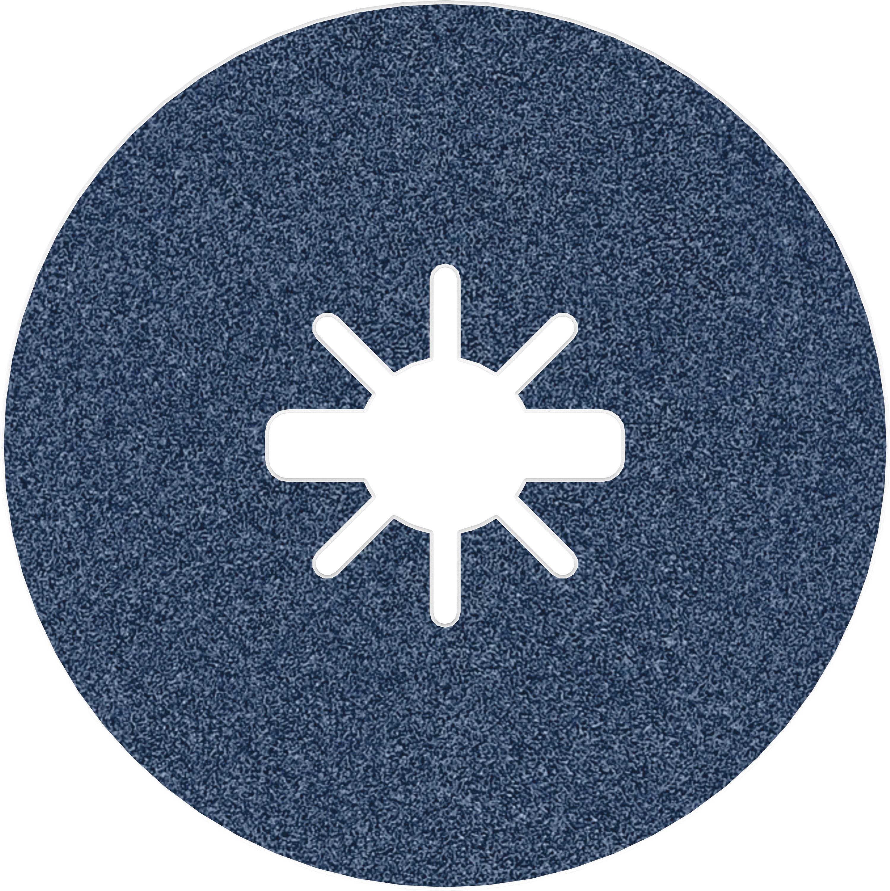 A circular grinding disc with a star-shaped slot in the centre, on a rough, dark surface.