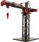 A model construction crane made of red and black components stands on a rectangular base. The crane has a long jib with a hook.