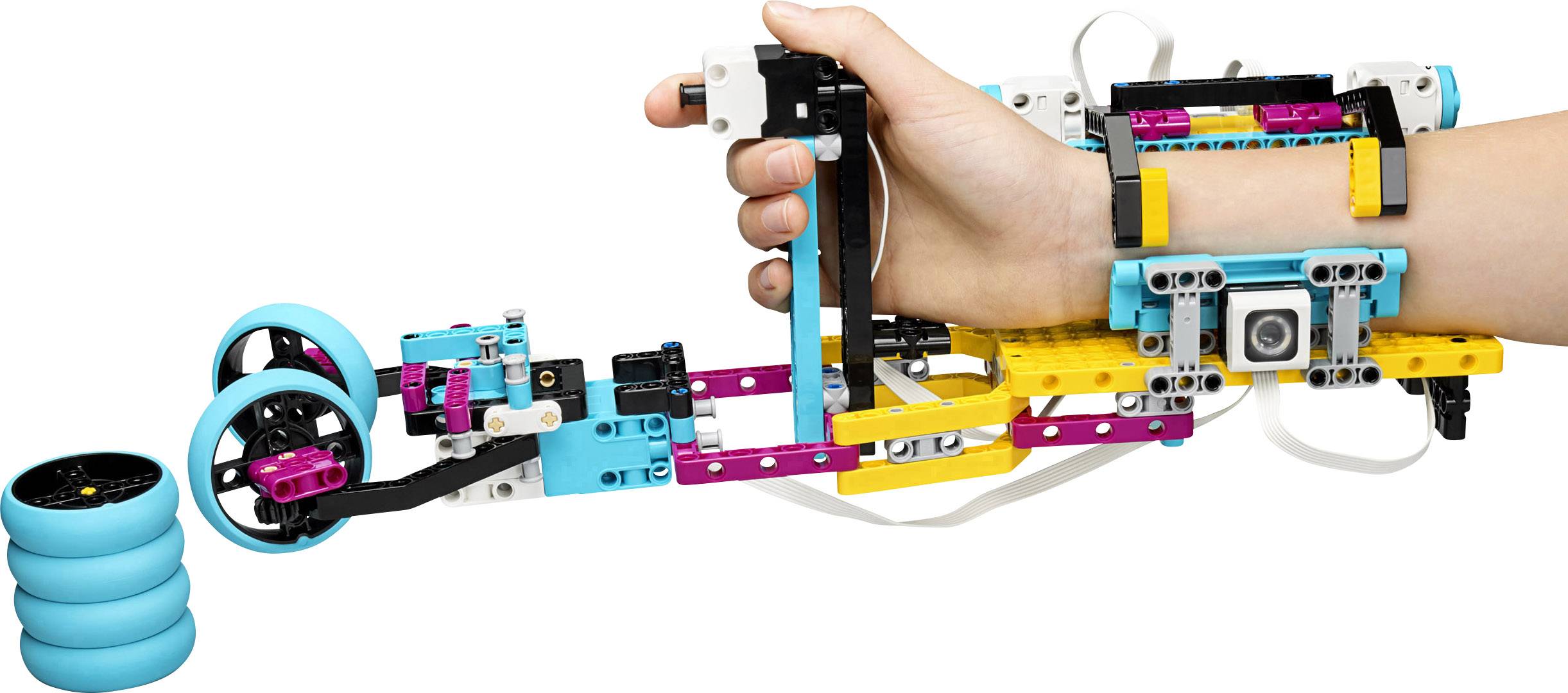 A child is holding a colourful robotic hand made from LEGO pieces, which appears capable of grasping a ball or an object.