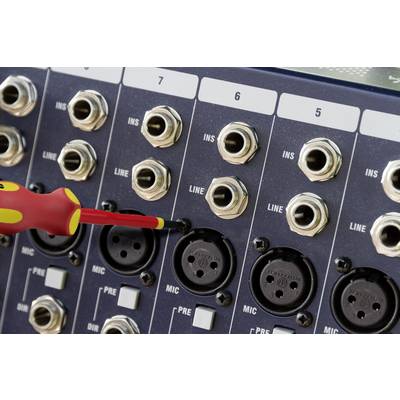 'Close-up of a mixing desk with XLR and jack inputs. A screwdriver is adjusting a connection in the mic pre row.'