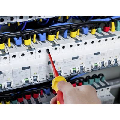A hand holds a screwdriver and is working on a fuse box with switches and colourful wires.
