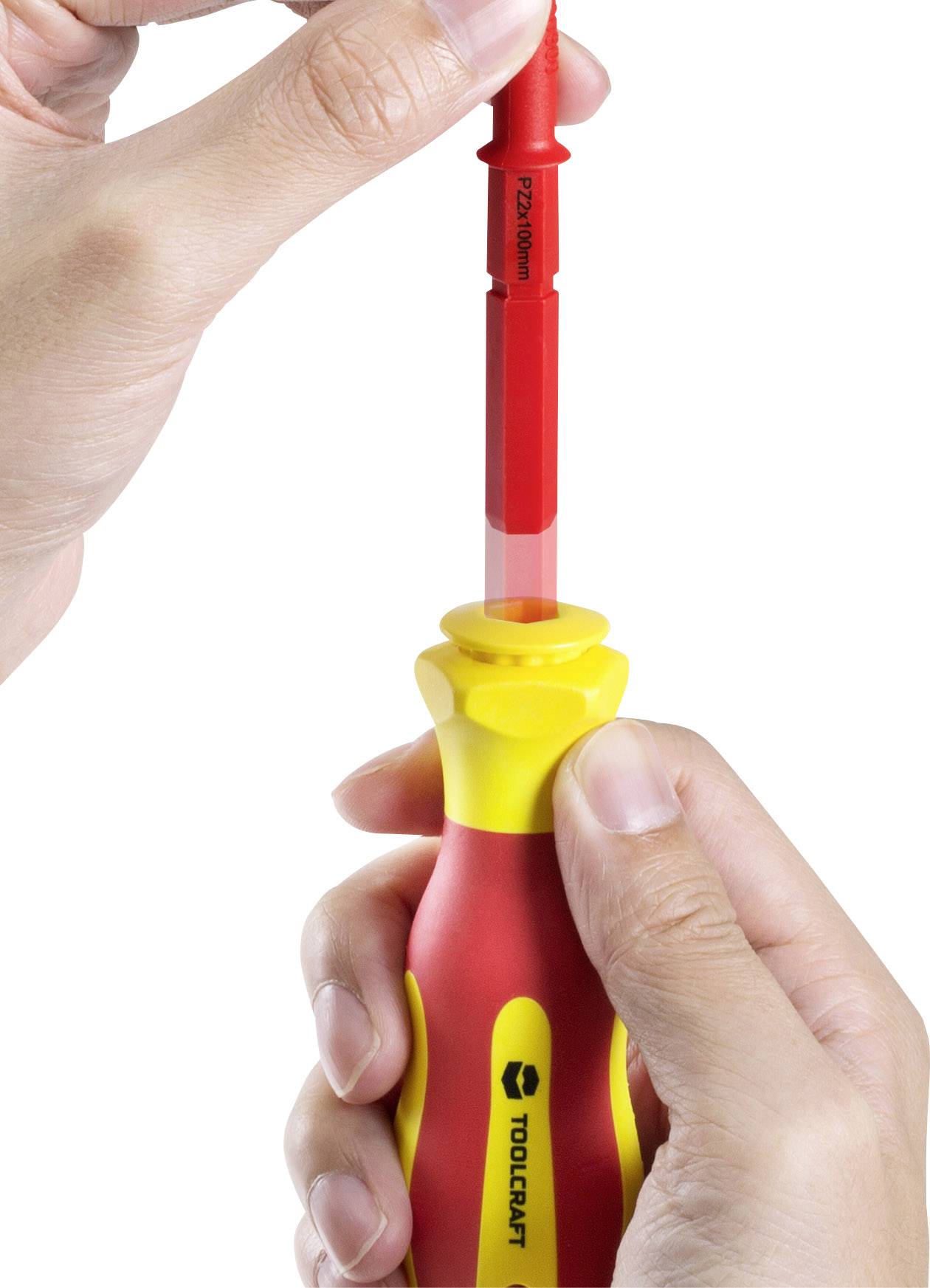 A hand holds a screwdriver with a red, insulated shaft; shows how the shaft is inserted into the yellow and red handle.