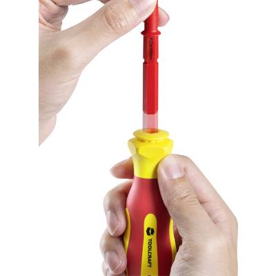 A hand holds a screwdriver with a red, insulated shaft; shows how the shaft is inserted into the yellow and red handle.