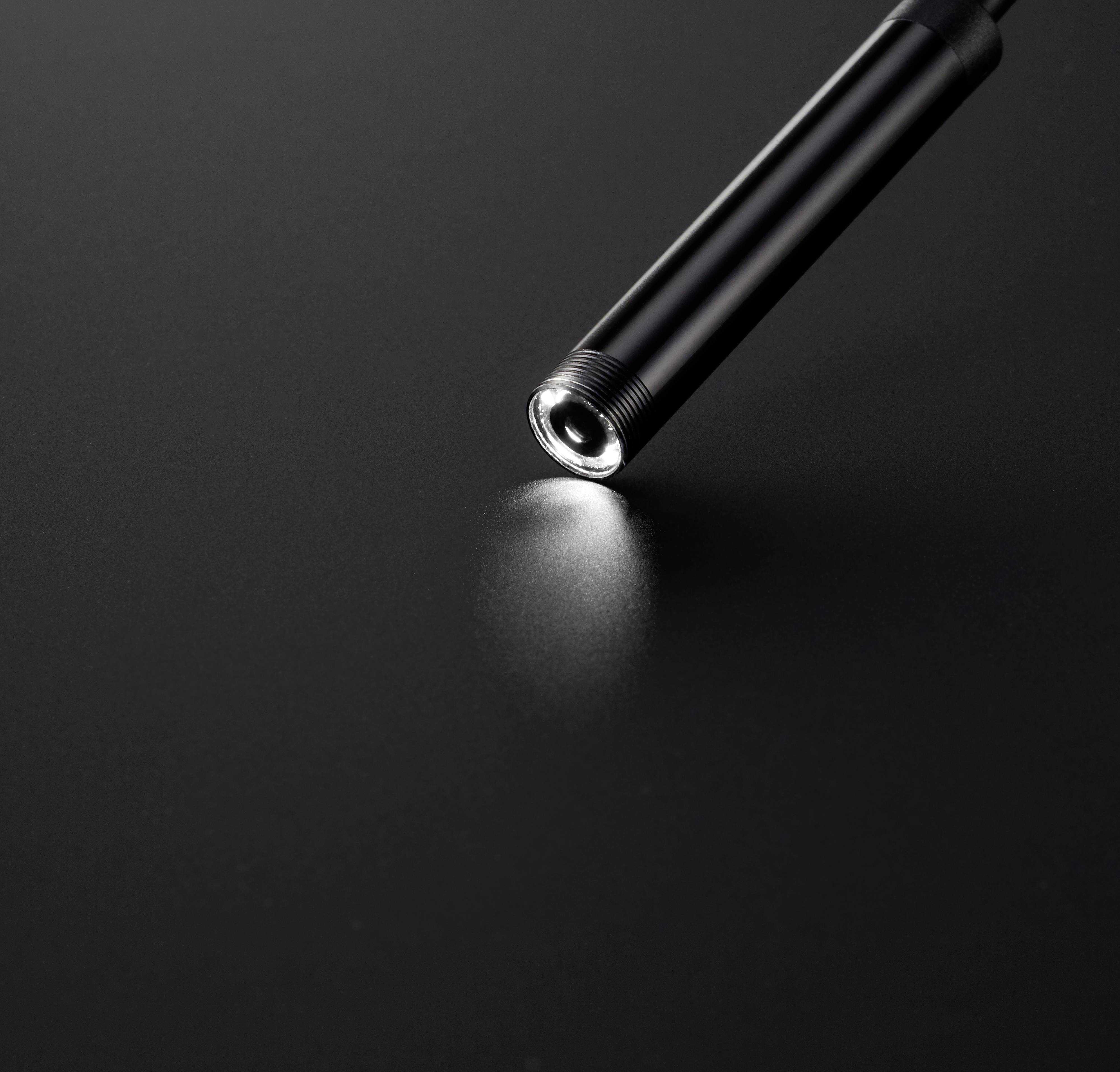 Black torch illuminates dark grey surface. Light cone visible.