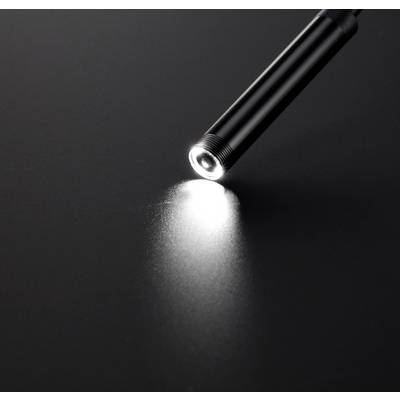 A pen with strong light shines on a dark surface and creates a small point of light.