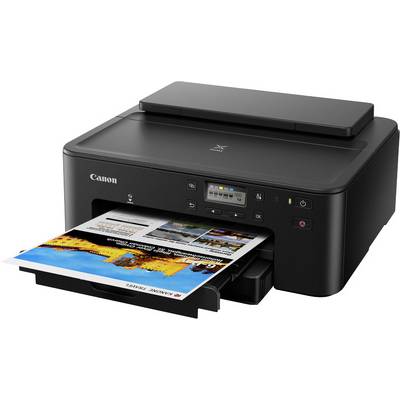 A black Canon printer is printing a colour photograph, visible in the paper tray. The printer has control buttons and a display.