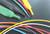 Multicoloured electrical cables and heat-shrink tubing on a black background. The cables are arranged in various colours.