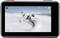A snowboarder dynamically rides across a snow-covered ski slope. A camera screen displays the recording with various display settings.
