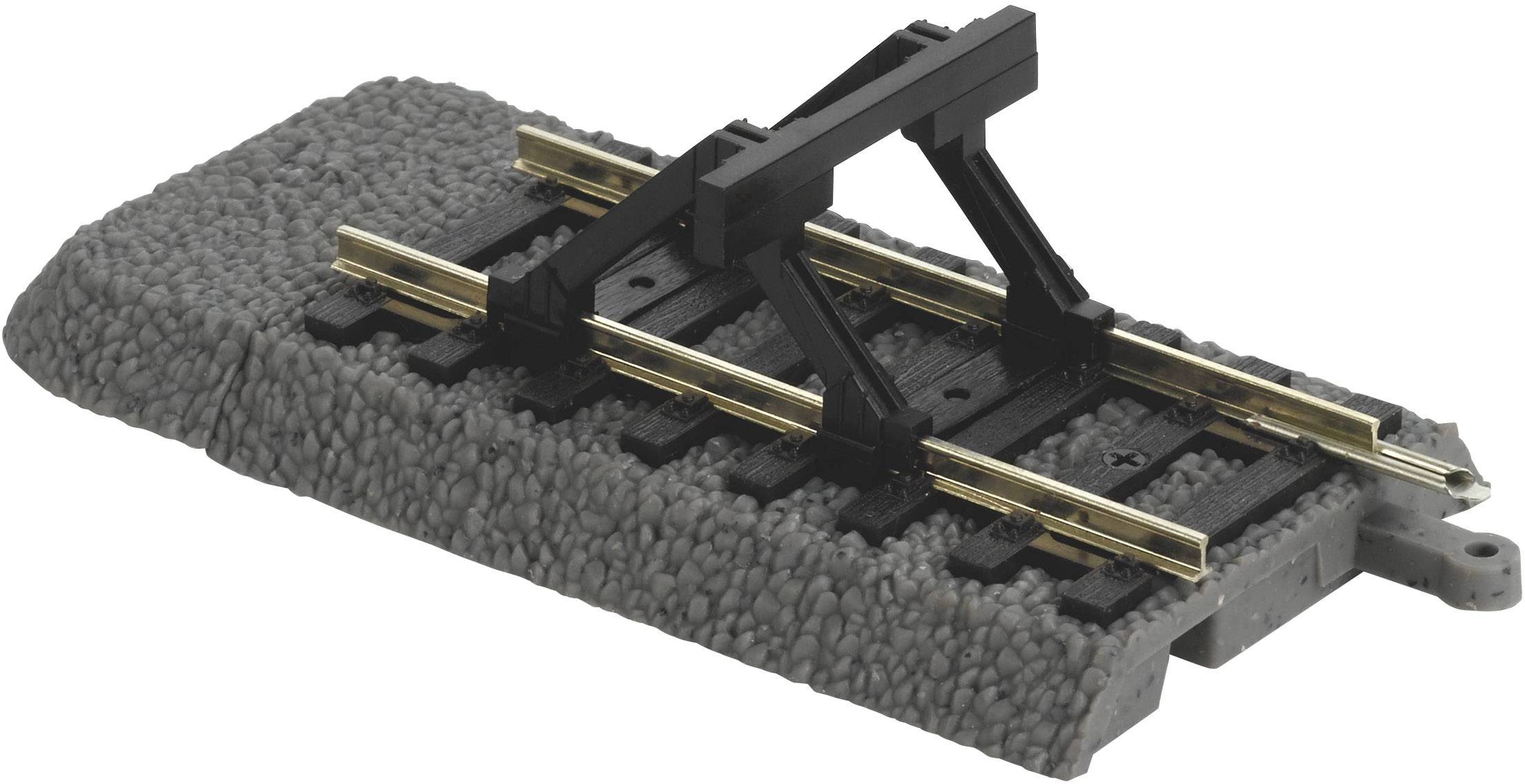 Plastic model of a railway track section with a dark sleeper, golden rails, and a black bridge construction on top.
