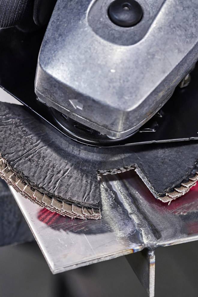 An angle grinder is processing a metal surface. The sparks demonstrate the working process while the device is in operation.