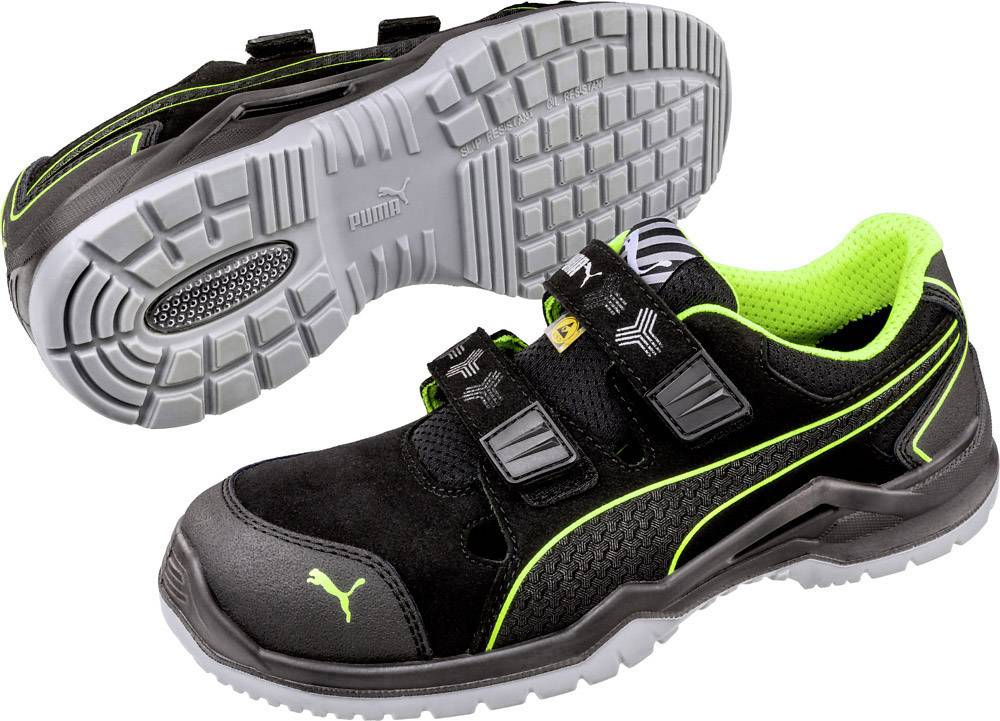 Black safety shoe with green accents and two hook and loop fasteners. Robust grey sole with non-slip tread. Suitable for work environments.
